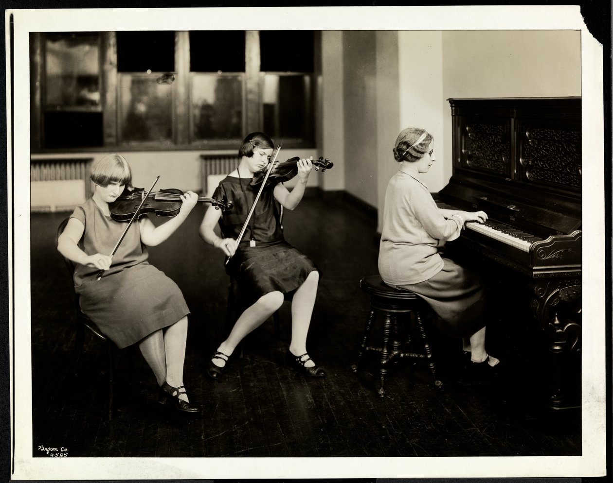 Kolmen nuoren sokean naisen ryhmä, yksi pianon ääressä, kaksi soittamassa viulua, New York Association for the Blind, 111 East 59th Street, New York, 1926 (hopeagelatiiniprintti) tekijältä Byron Company