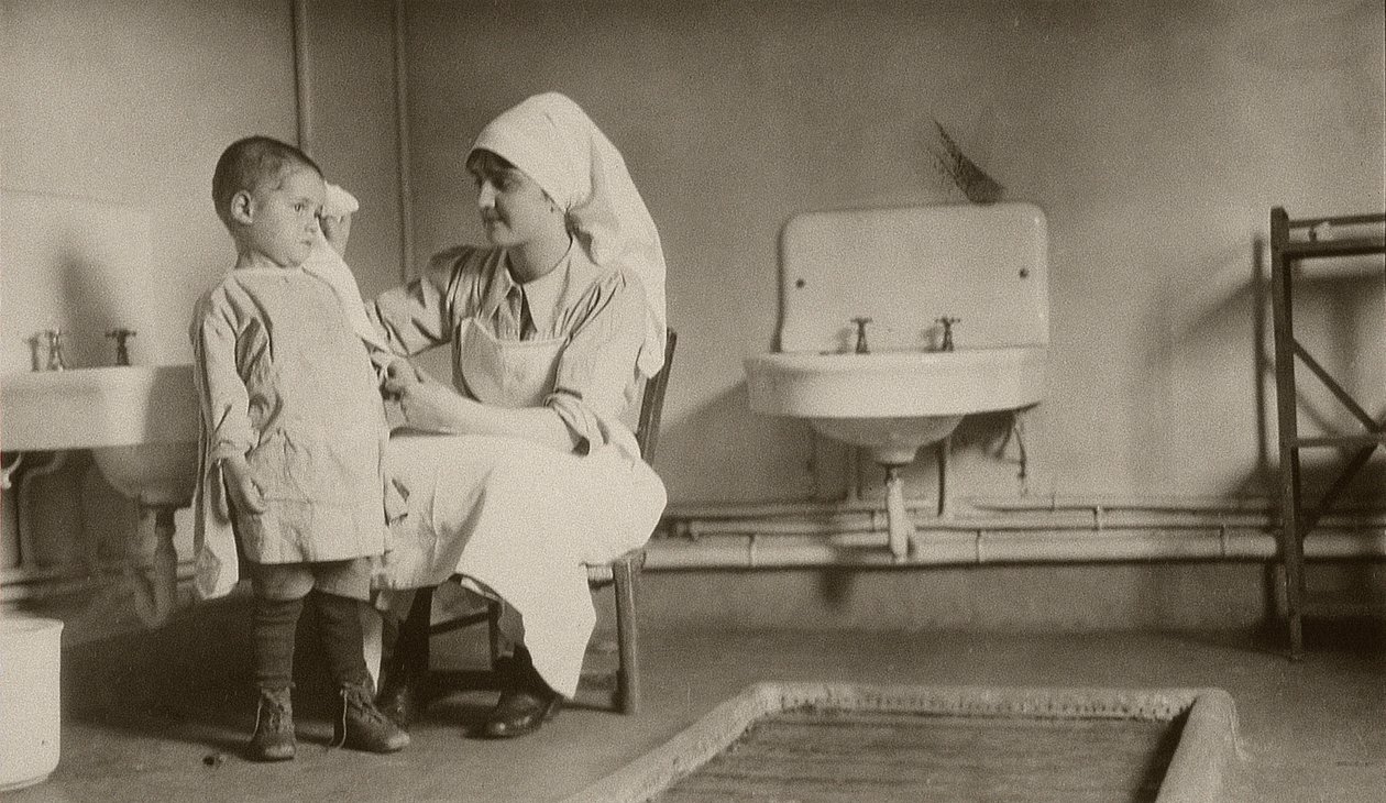 Sairaanhoitaja hoitaa sairasta lasta Passayn ja Saint-Quentinin pakolaisten ja orpojen siirtokunnissa, 1919 tekijältä American Photographer