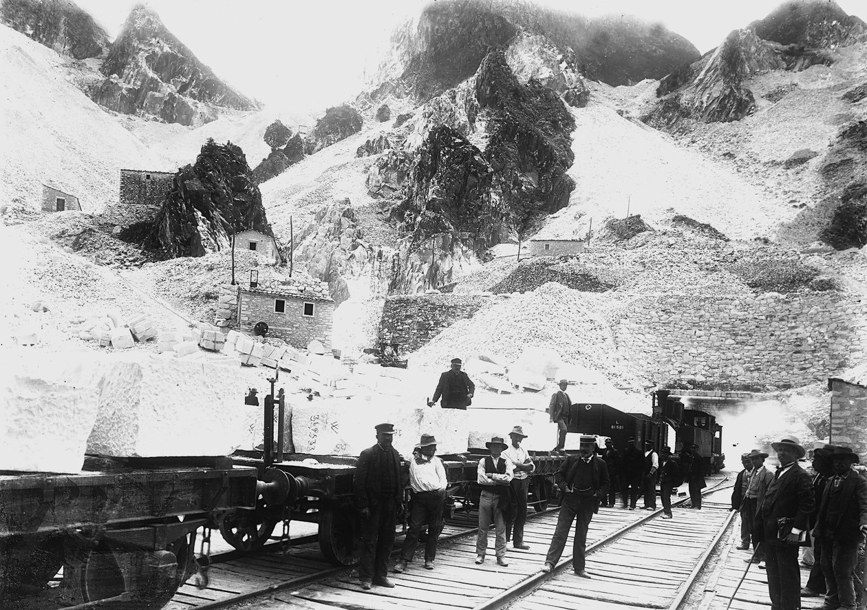 Kaivinkoneet marmorilohkoilla lastatun rautatiesaattueen edessä Ravaccionessa, Apuan Alpeilla (m/v kuva) tekijältä A. Corsini