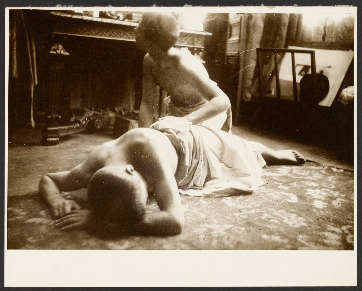 [Kaksi puolialastonta miestä studion lattialla] tekijältä Alphonse Maria Mucha