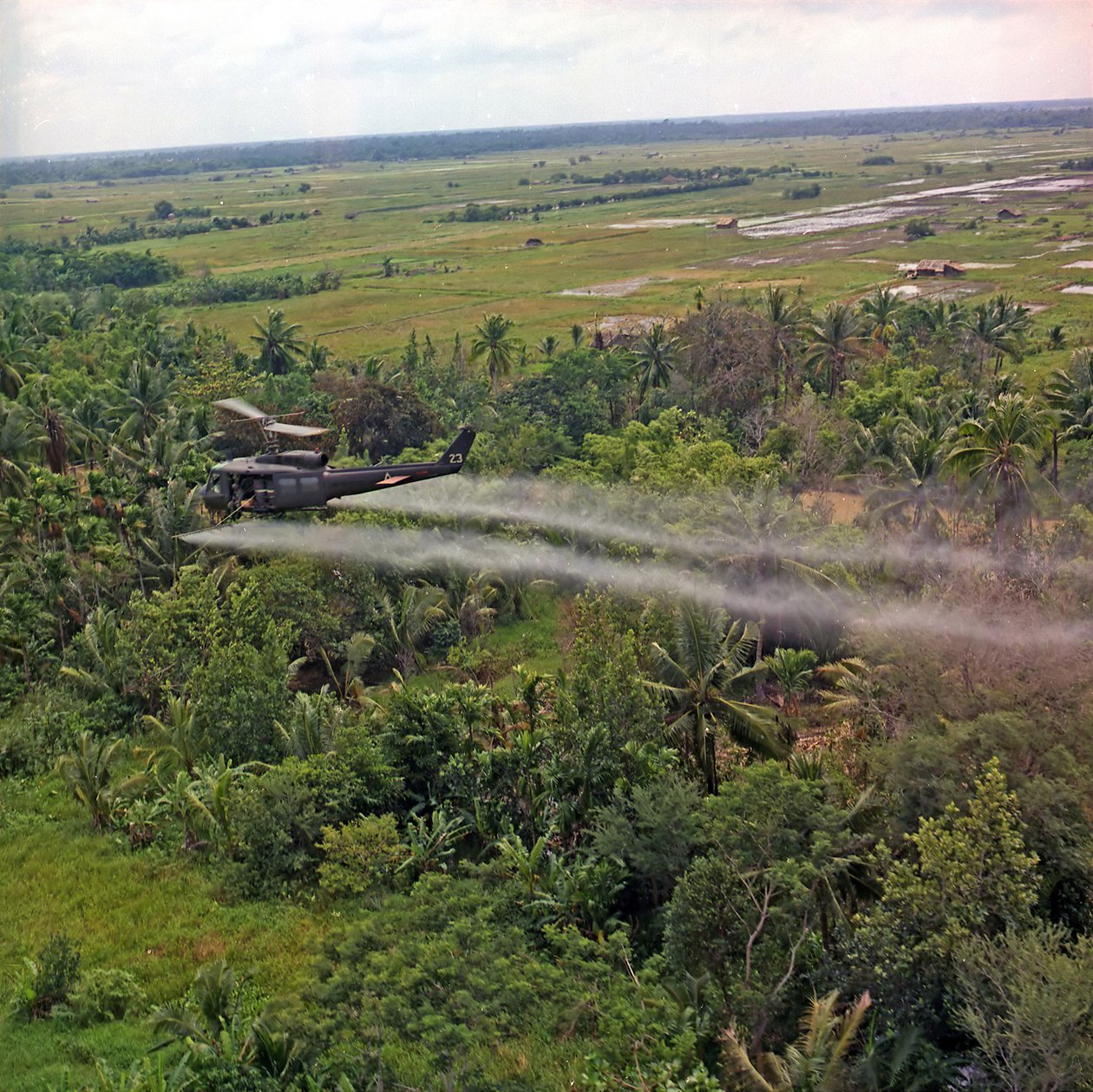 336th Aviation Companyn UH-1D-helikopteri suihkuttaa lehtienpoistoainetta tiheälle viidakkoalueelle Mekongin suistossa, 26. heinäkuuta 1969 tekijältä American Photographer