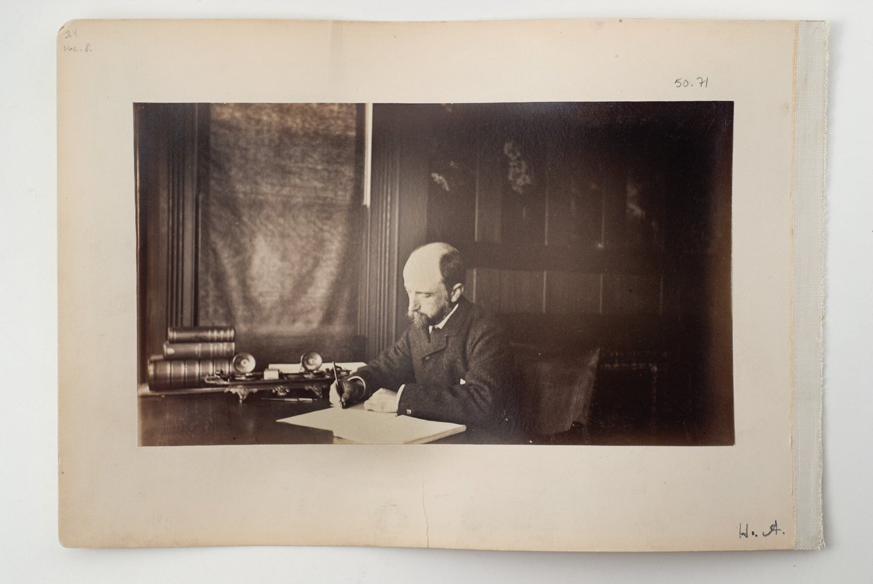 Henry Adams istuu pöydän ääressä, 1883 tekijältä American Photographer