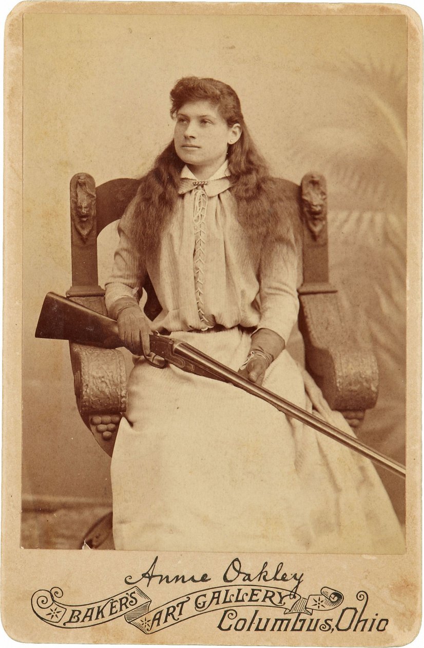 Annie Oakley: Annie Oakley:. Täällä Legendaarinen ampuja istuu melko nöyrästi massiivisessa renessanssityylisessä tuolissa, haulikko lepää sylissään. Hänen herkät naiselliset piirteensä ja kiiltoiset hiuksensa luopuvat hänen karuista ulkoilmakuvastaan ©Buy tekijältä American Photographer