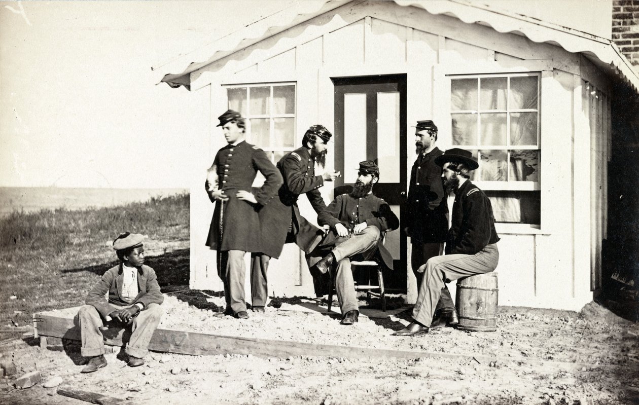 Viisi sisällissodan sotilasta kokoontui likakuistille kodin ulkopuolelle, afroamerikkalaiset nuoret istuivat heidän lähellään, 1861-65 tekijältä American Photographer