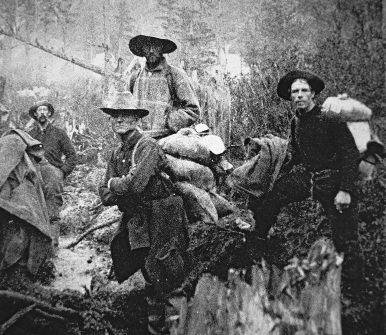 Kullanetsijät muuttamassa Yukonin alueelle Kanadaan Klondiken kultakuumeen aikana (1897-1898) (m/v kuva) tekijältä American Photographer