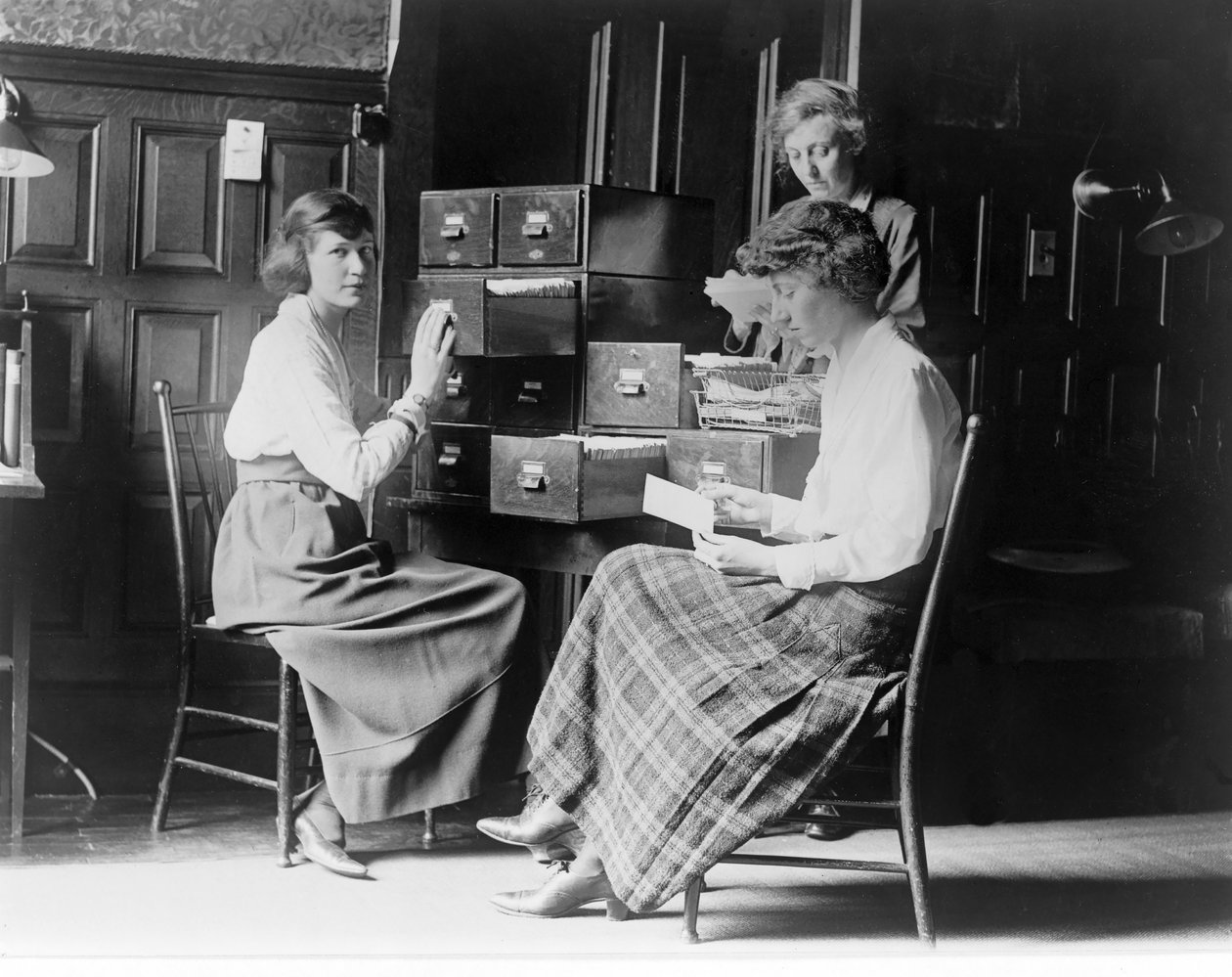 Kolme naista työskentelee kortistotiedostoissa National Womans Partyn päämajassa Washington D.C.:ssä, pubissa. noin 1920 tekijältä American Photographer