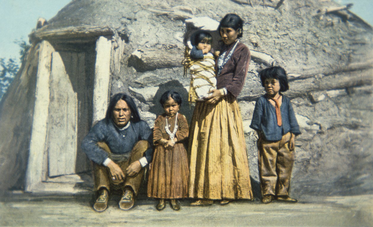 Postikortti navajo-intialaisesta perheestä talonsa ulkopuolella tai "hogan" tekijältä American School