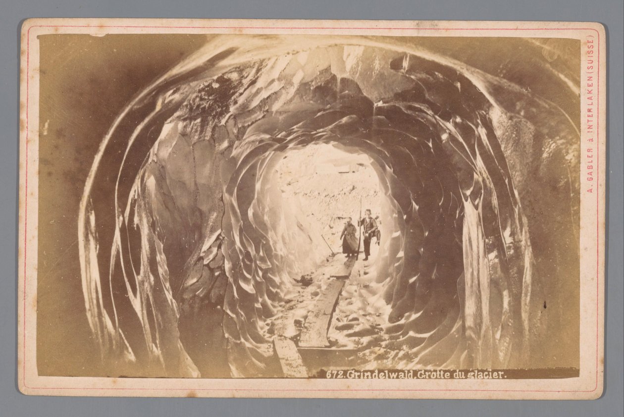 Ihmisiä luolassa Grindelwaldin jäätiköllä Sveitsissä Grindelwald. Cave of the Glacier (otsikko esineessä) tekijältä Arthur Gabler
