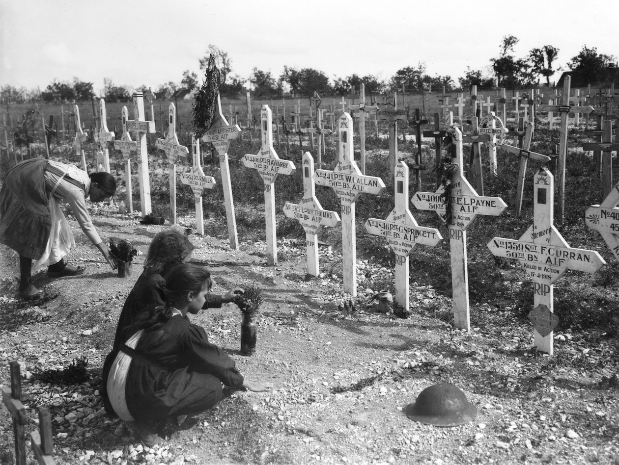 Ranskalaiset lapset hoitavat hautoja länsirintaman taistelussa kuolleiden australialaisten Adelaiden hautausmaalla, Villers-Bretonneux, Ranska 26. elokuuta 1919 tekijältä Australian Photographer