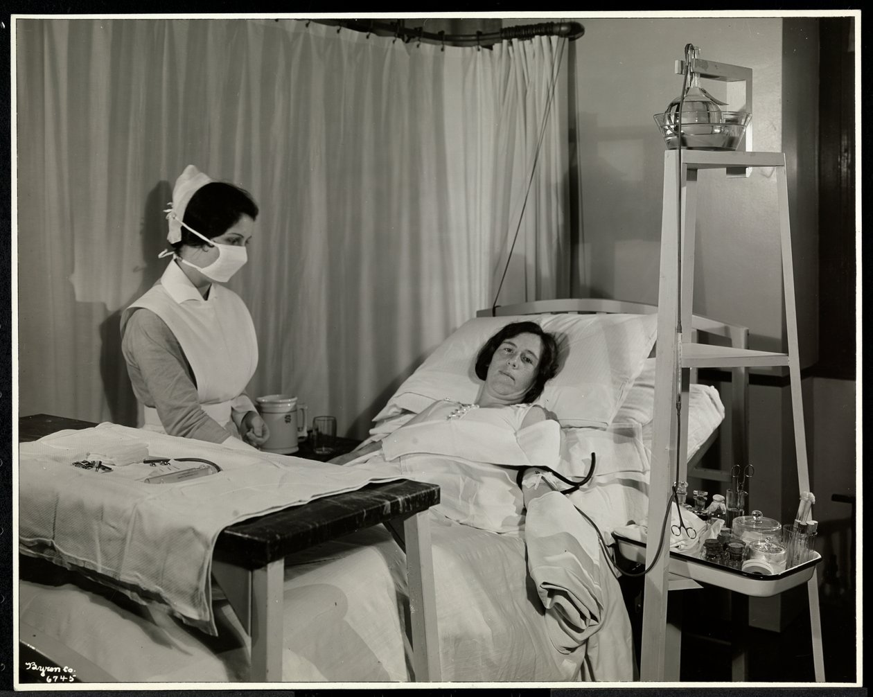 Naamioitu sairaanhoitaja potilaan kanssa huoneessa Sloane Medical Hospitalissa, Broadwayssa ja 168th Streetissä New Yorkissa, 1932 (hopeagelatiiniprintti) tekijältä Byron Company