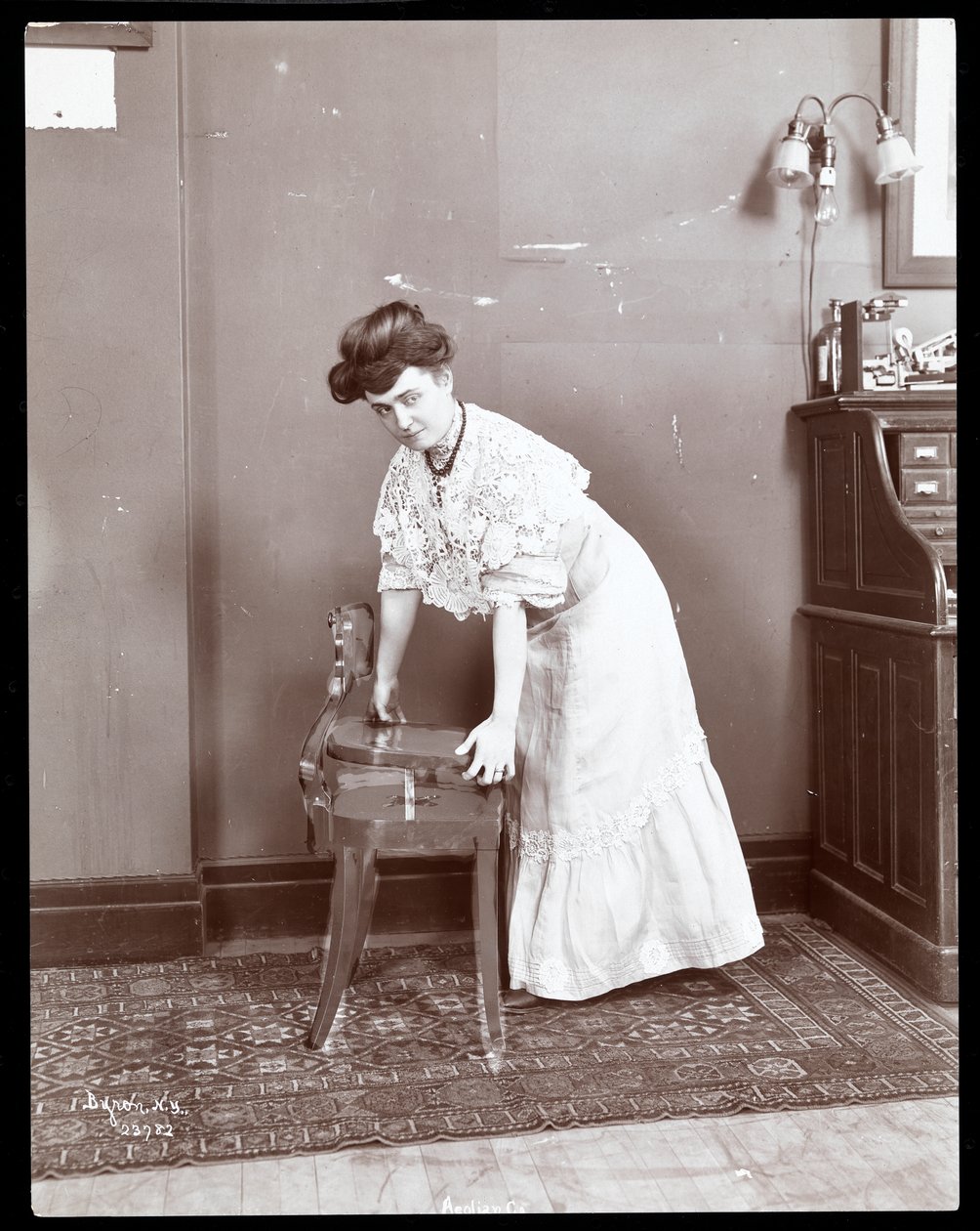 Nainen esittelee erikoistuolia Aeolian Co.:ssa, New Yorkissa, 1906 tai 1907 (hopeagelatiiniprintti) tekijältä Byron Company