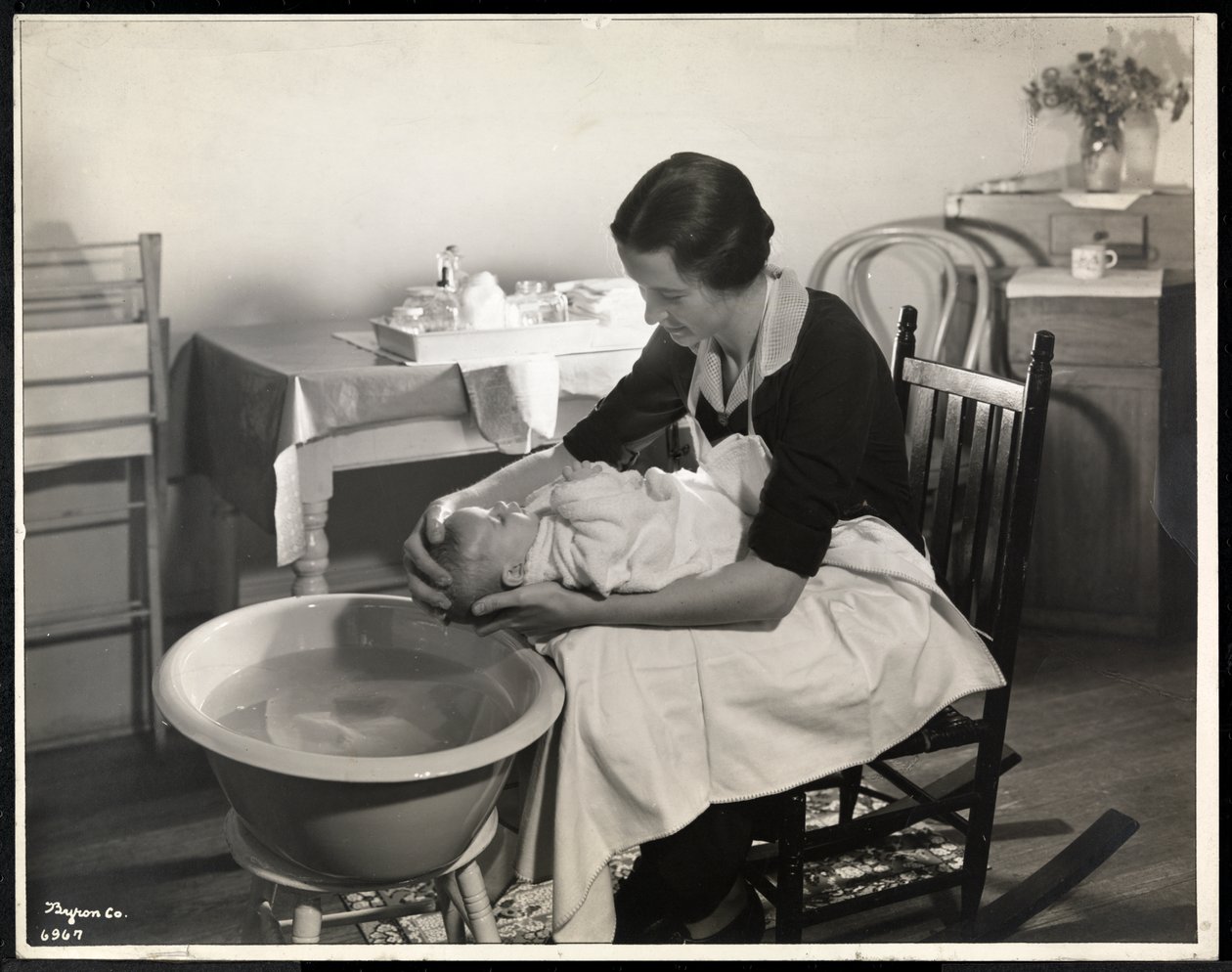 Nainen pesemässä vauvan päätä Maternity Center Associationissa osoitteessa 211 East 57th Street, New York, 1934 (hopeagelatiiniprintti) tekijältä Byron Company