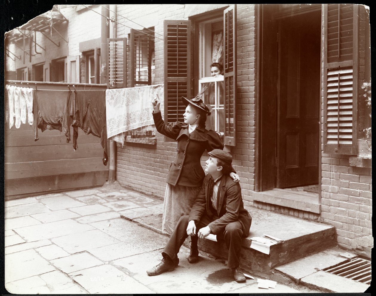 Nuori mies ja nainen poseerasivat ovella, New York, 1896-98 (hopeagelatiiniprintti) tekijältä Byron Company