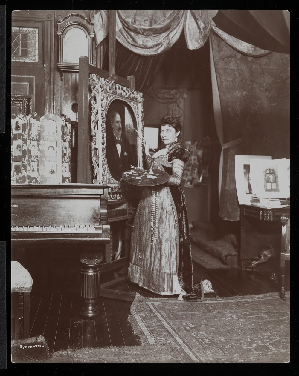 Taiteilija Mary Tillinghast maalaa muotokuvan studiossaan New Yorkissa, n. 1897 (hopeagelatiiniprintti) tekijältä Byron Company