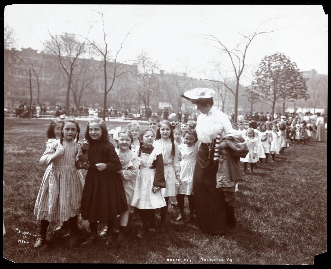 Lapset naisen johdolla pitkässä jonossa Tompkins Square Parkissa New Yorkissa, 1904 (hopeagelatiiniprintti) tekijältä Byron Company