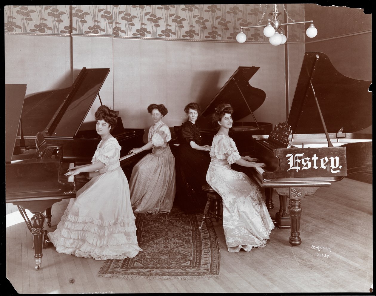 Neljä naista istuu pianon ääressä Estey Piano Corporationissa, 1908 (hopeagelatiinivedos). tekijältä Byron Company