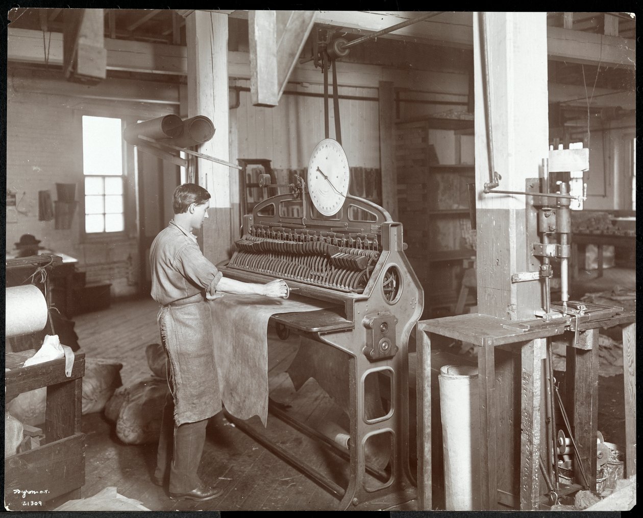 Sisäkuva miehestä, joka työskentelee nahkaa New York Leather Belting Co.:ssa, New York, 1906 (hopeagelatiiniprintti) tekijältä Byron Company