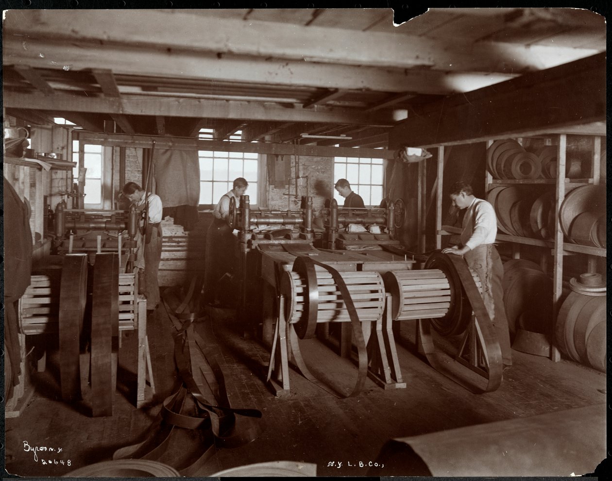 Sisäkuva miehistä, jotka työskentelevät nahkaa New York Leather Belting Co.:ssa, New York, 1905 (hopeagelatiiniprintti) tekijältä Byron Company