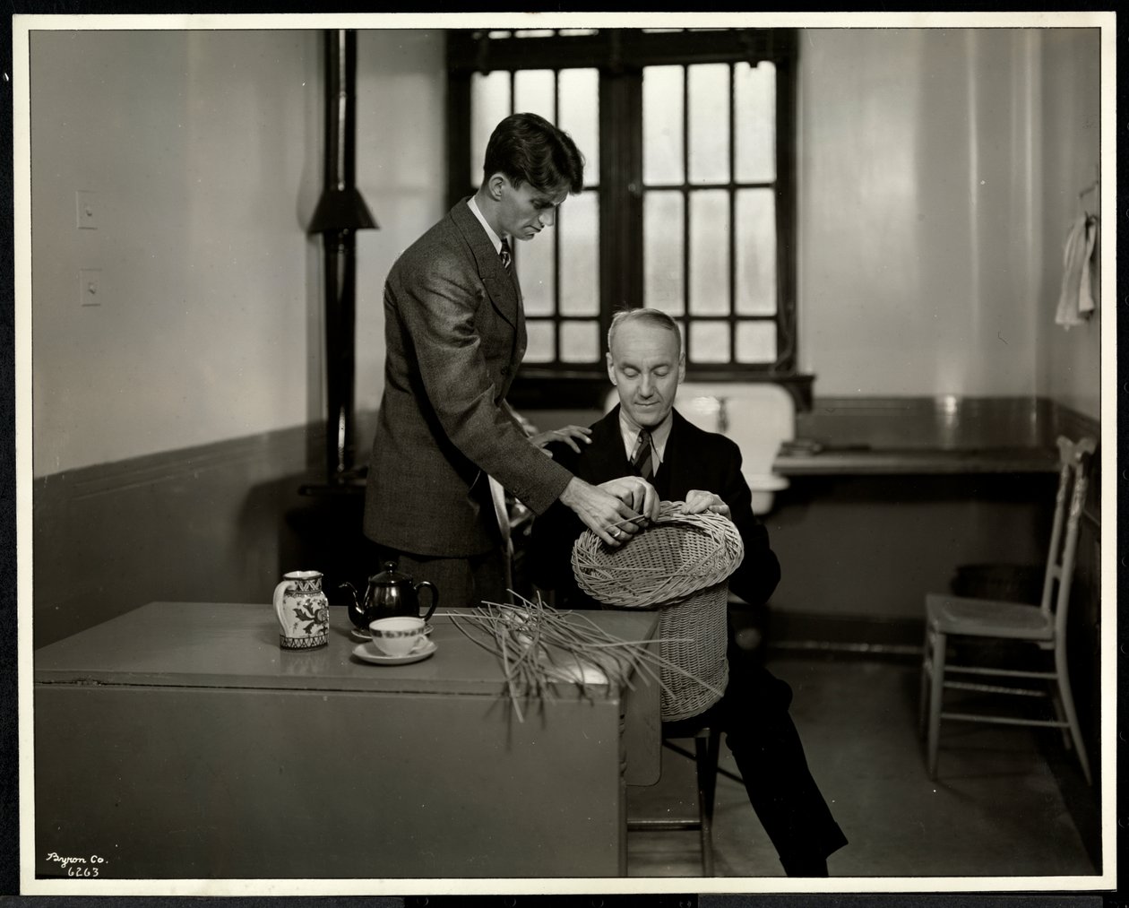 Mies opettaa toiselle miehelle korintekoa New York Association for the Blindissa, 111 East 59th Street, New York, 1931 (hopeagelatiiniprintti) tekijältä Byron Company