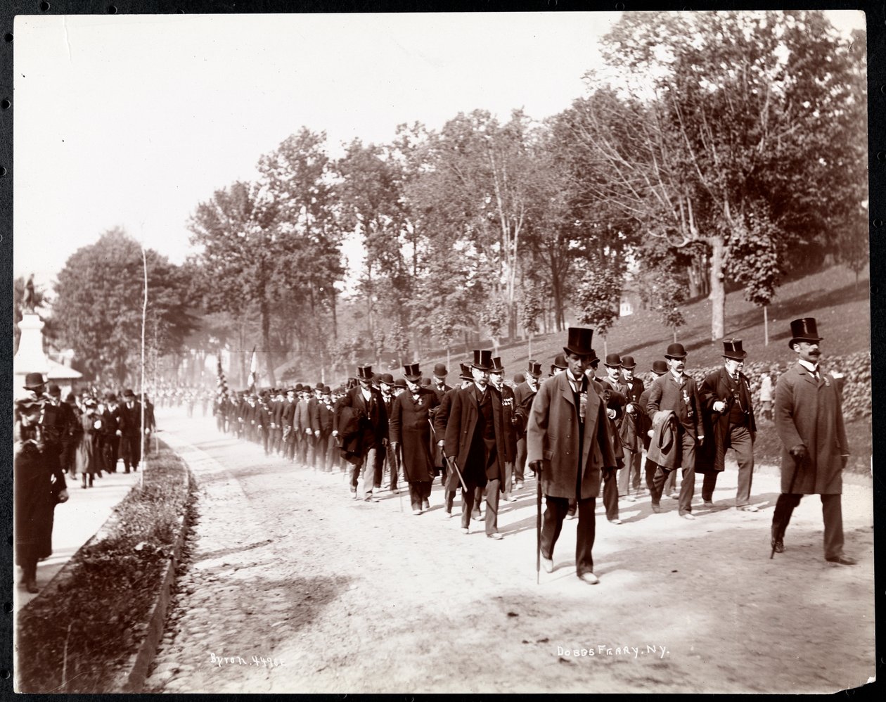 Sotilasparaati, jossa on univormupukuisia miehiä silinterihattu päässään Dobbs Ferryssä, New Yorkissa, 1898 (hopeagelatiinipainatus) tekijältä Byron Company