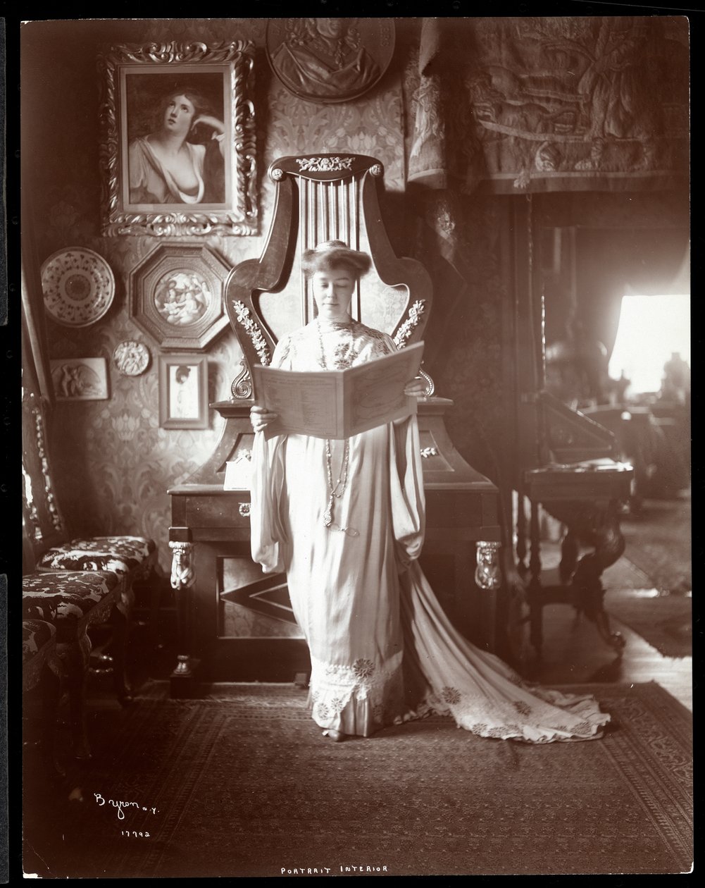Muotokuva rouva I. M. Clark seisomassa avoinna oleva kirja kädessään, 1904 (hopeagelatiinivedos) tekijältä Byron Company
