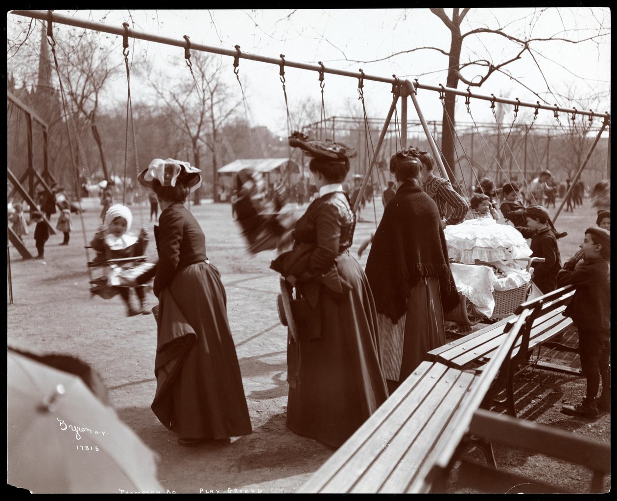 Näkymä naisesta, joka työntää lapsia keinuissa Tompkins Square Parkissa, Arbor Day, New York, 1904 (hopeagelatiiniprintti) tekijältä Byron Company