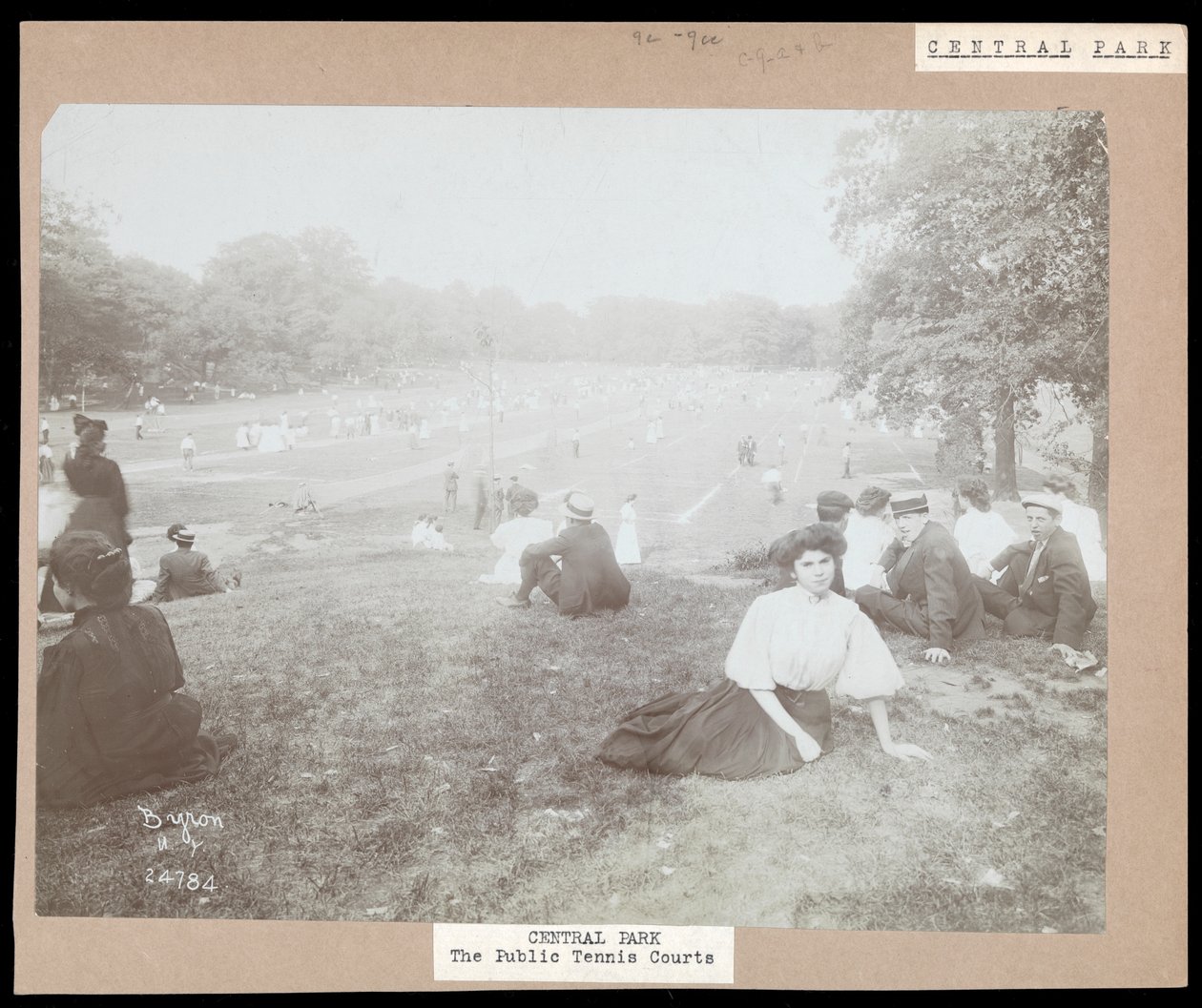 Näkymä miehistä ja naisista, jotka istuvat nurmikolla katsomassa nurmikkotennistä Central Parkissa, New Yorkissa, n. 1917 (hopeagelatiiniprintti) tekijältä Byron Company