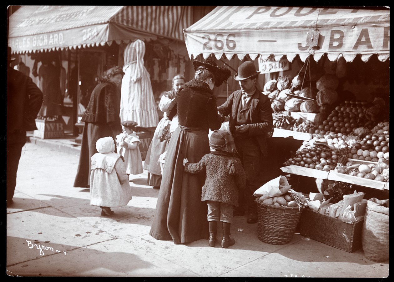 Näkymä naisista lasten kanssa ostoksilla hedelmä- ja vihannesosastolla osoitteessa 266 7th Avenue, New York, n. 1900 (hopeagelatiiniprintti) tekijältä Byron Company