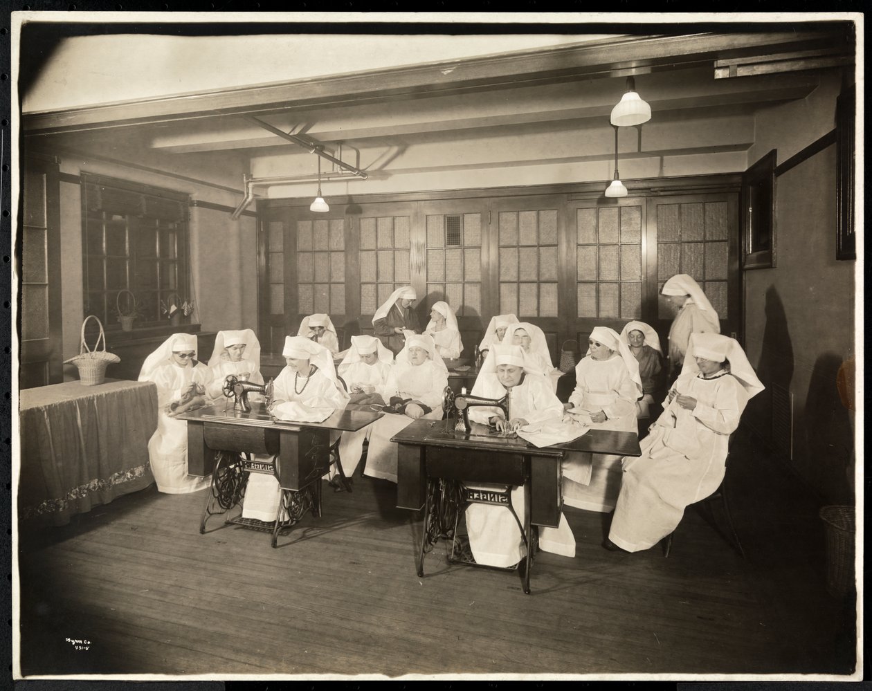 Naiset, jotka käyttävät valkoisia housuja, ompelutunnilla, oletettavasti ensimmäisen maailmansodan aikana tai liittyvät siihen, New York, n. 1920 (hopeagelatiiniprintti) tekijältä Byron Company
