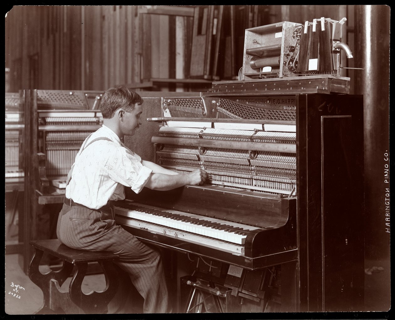 Mies työskentelee Harrington Piano Co.:n tehtaalla, 1907 (hopeagelatiiniprintti) tekijältä Byron Company