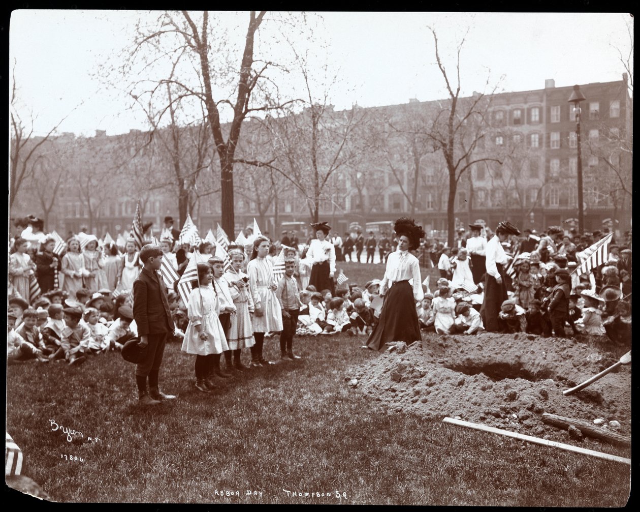 Aikuiset ja lapset pitelevät lippuja seisomassa juuri kaivetun reiän ympärillä puunistutusta varten Arbor Dayna Tompkins Square Parkissa, New Yorkissa, 1904 (hopeagelatiiniprintti) tekijältä Byron Company