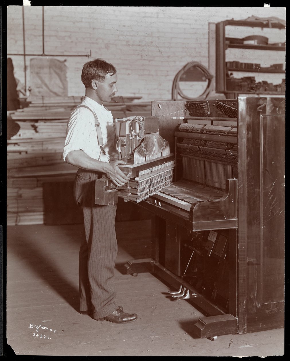 Mies työskentelee Hardman, Peck und Co:n pianotehtaalla, New York, 1907 (hopeagelatiiniprintti) tekijältä Byron Company