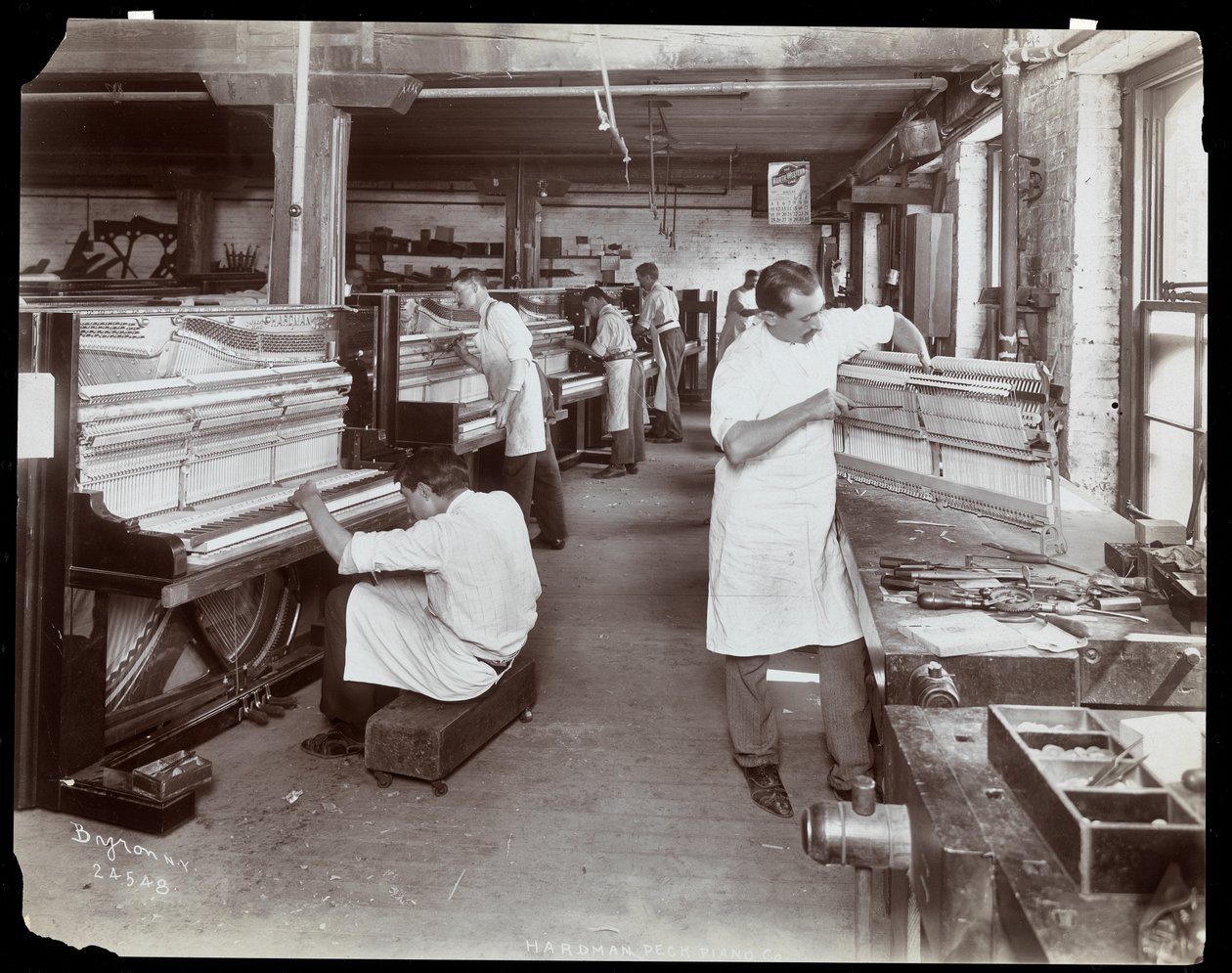 Miehet työskentelevät Hardman, Peck und Co:n pianotehtaassa, New York, 1907 (hopeagelatiiniprintti) tekijältä Byron Company