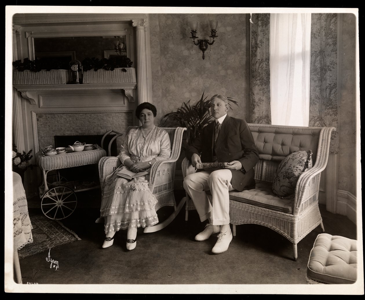 Muotokuva herra ja rouva Howardista istumassa istumahuoneessa heidän kotonaan osoitteessa 200 5th Avenue, New York, 1916-6 (hopeagelatiinivedos). tekijältä Byron Company