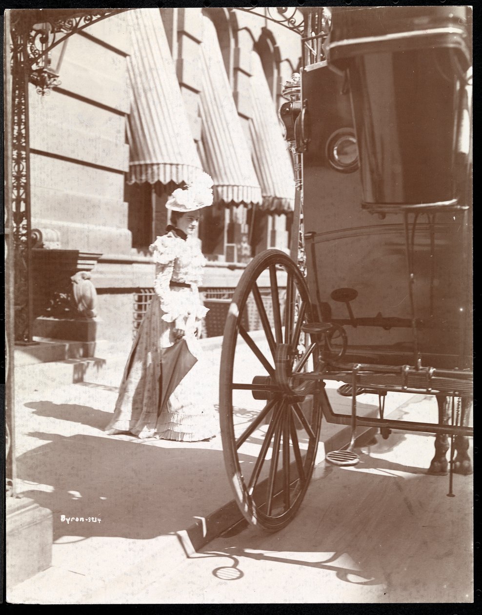 Nainen lähestyy vaunuja Waldorf Astoria -hotellissa, 34th Street ja 5th Avenue, New York, 1897 tai 1898 (hopeagelatiiniprintti) tekijältä Byron Company