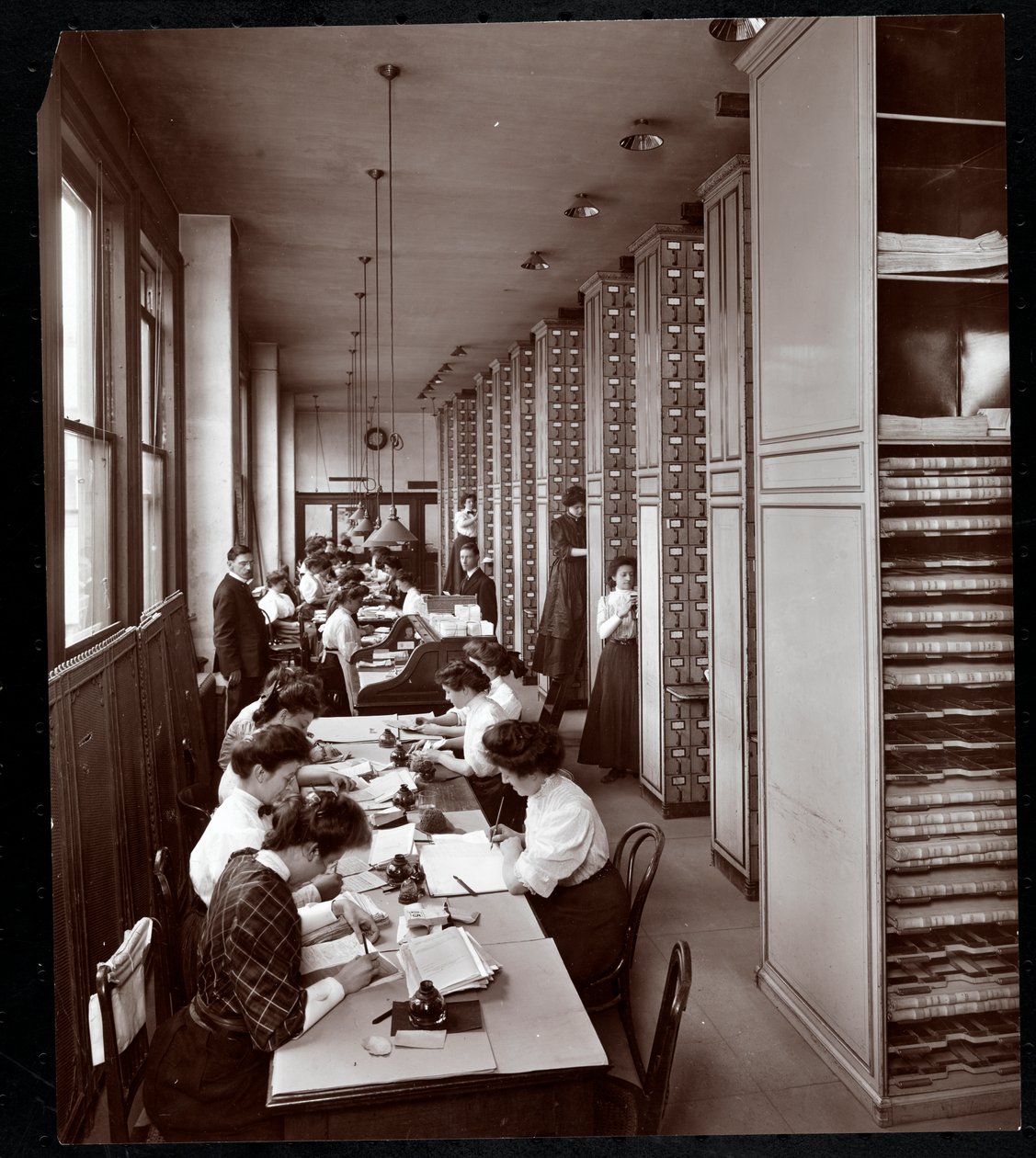 Naiset työskentelevät arkistointihuoneessa, miehen valvonnassa, Metropolitan Life Insurance Co.:ssa osoitteessa 23rd Street ja Madison Avenue, New York, 1907 (hopeagelatiiniprintti) tekijältä Byron Company