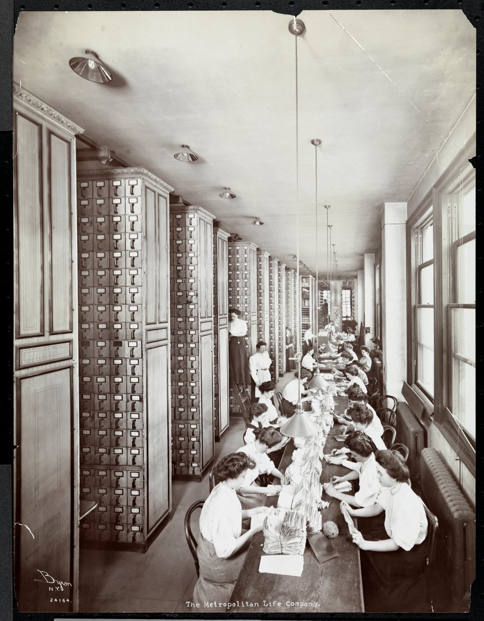 Naiset työskentelevät arkistointihuoneessa, miehen valvonnassa, Metropolitan Life Insurance Co.:ssa osoitteessa 23rd Street ja Madison Avenue, 1907 (hopeagelatiiniprintti) tekijältä Byron Company