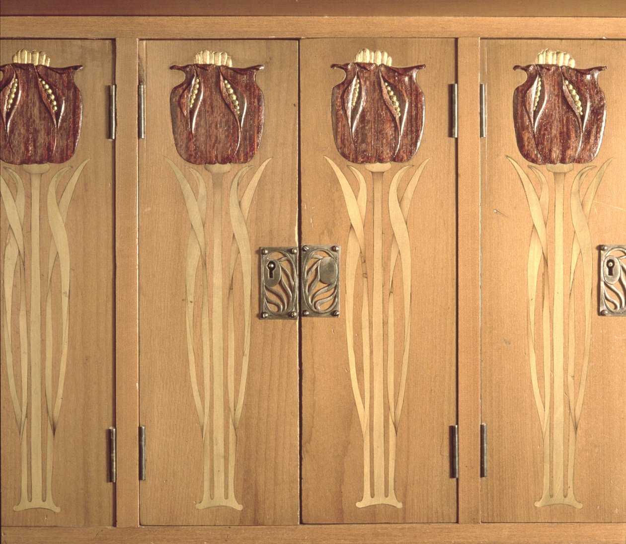 Yksityiskohta kaapin kaiverretusta upotekoristeesta, Guild of Handicraftin valmistama, n. 1898-1899 (mahonki, holly ja messinki) tekijältä Charles Robert Ashbee