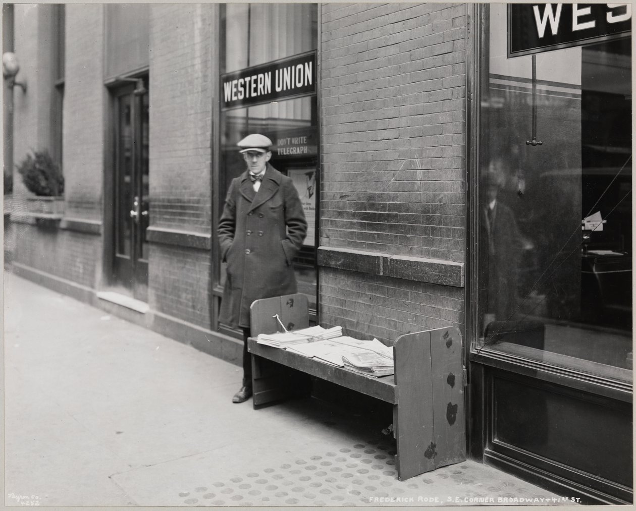Sokea lehtikauppias Frederick Rode Broadwayn ja 41st St:n kaakkoiskulmassa. Roden takana olevassa ikkunassa näkyy Western Unionin kyltti. tekijältä Company Byron