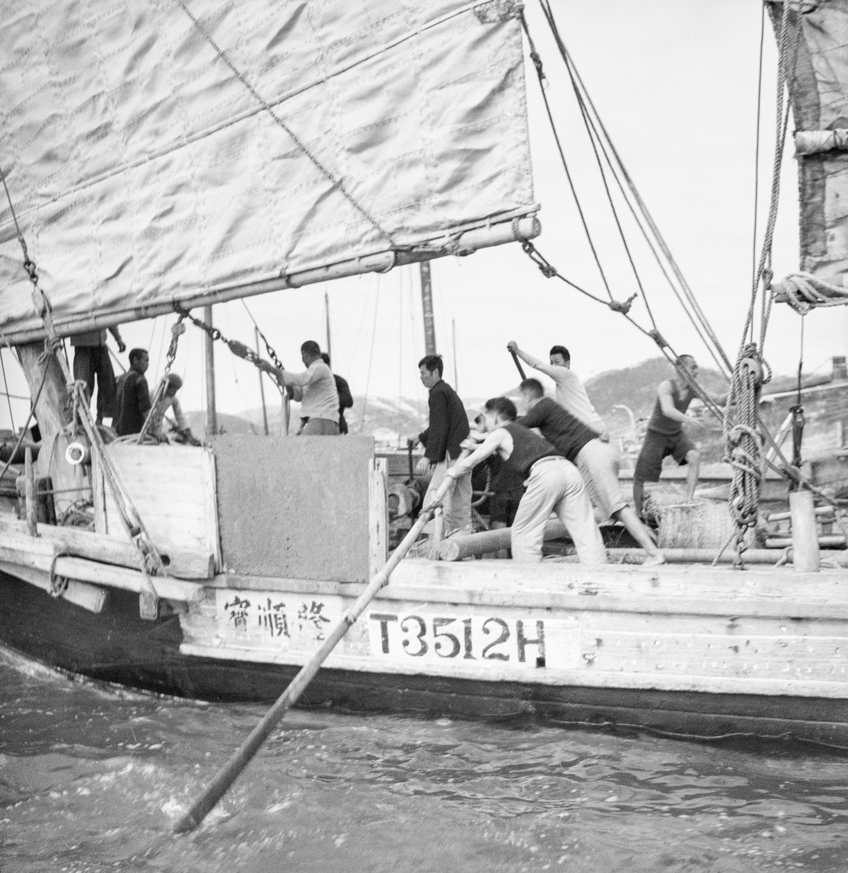 Hyvin läheinen satamanpuoleinen leveä sivukuva hongkongilaisesta pienestä kauppalaivasta T3512H, jota kuolataan Sham Shui Possa, Hongkongissa. tekijältä David Watkin Waters