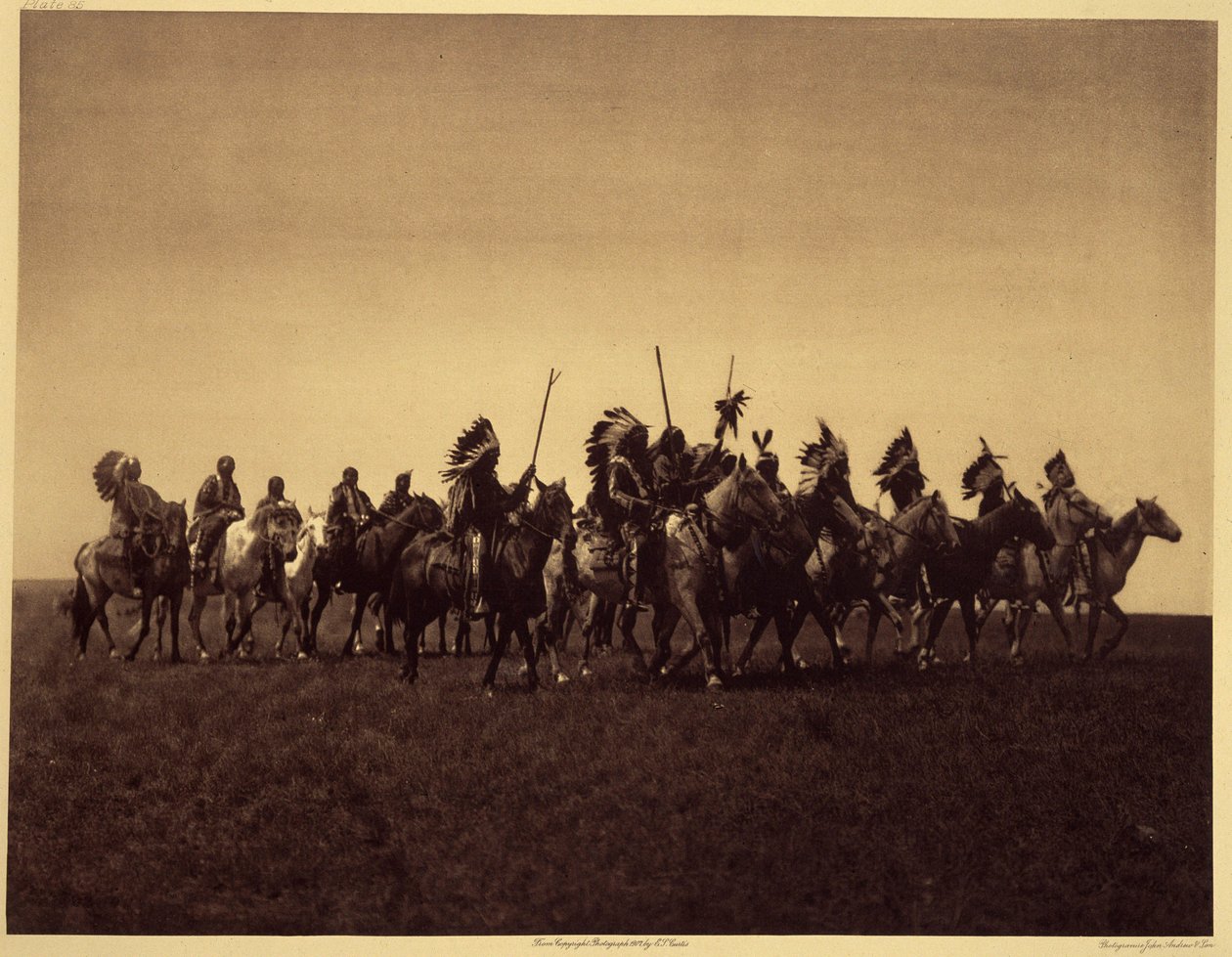 Brate sotajuhlat. Sioux Brules -ryhmä toistaa hyökkäyksen vihollista vastaan. Kuva otettu osasta 3 Edward S. Curtisin tietosanakirjasta (1868-1952) Pohjois-Amerikan intiaaneista, esipuheella Theodore Roosevelt. Vuosina 1907-1930 julkaistiin 20 osaa tekijältä Edward Sheriff Curtis