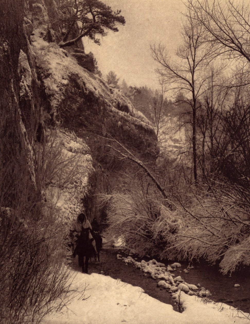 Kallion ohittaminen, talvimaisema. Apsaroke-intiaanit ratsastamassa kalliota pitkin lumessa Pryor-joella, Montanassa. Kuva otettu Edward S. Curtisin (1868-1952) Pohjois-Amerikan intiaaneja käsittelevän tietosanakirjan osasta 4, jossa on Theon esipuhe tekijältä Edward Sheriff Curtis