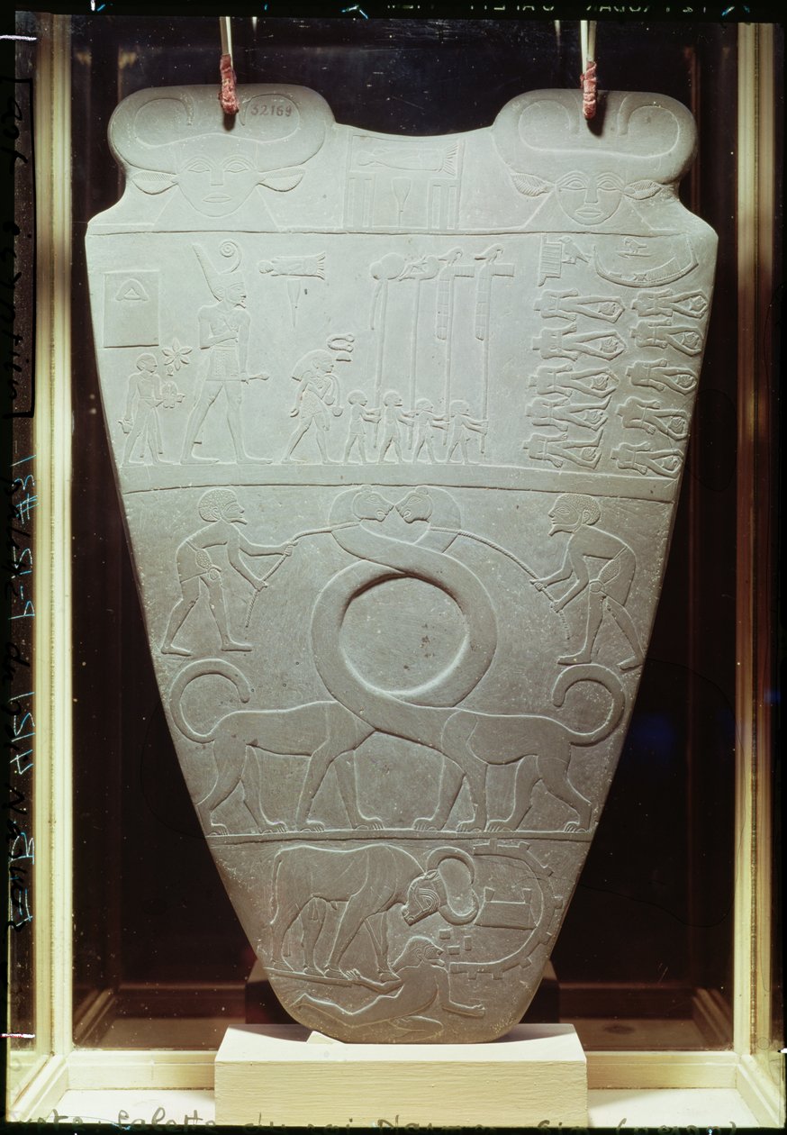 Narmer-paletti: seremoniallinen paletti, joka kuvaa kuningas Narmeria, joka pukeutuu Ala-Egyptin punaiseen kruunuun, tarkastamassa sidottuja ja katkaistuja vankeja, myös jättiläismäisiä, pitkäkaulaisia kissoja, löydetty Hieracosta. tekijältä Egyptian 1st Dynasty