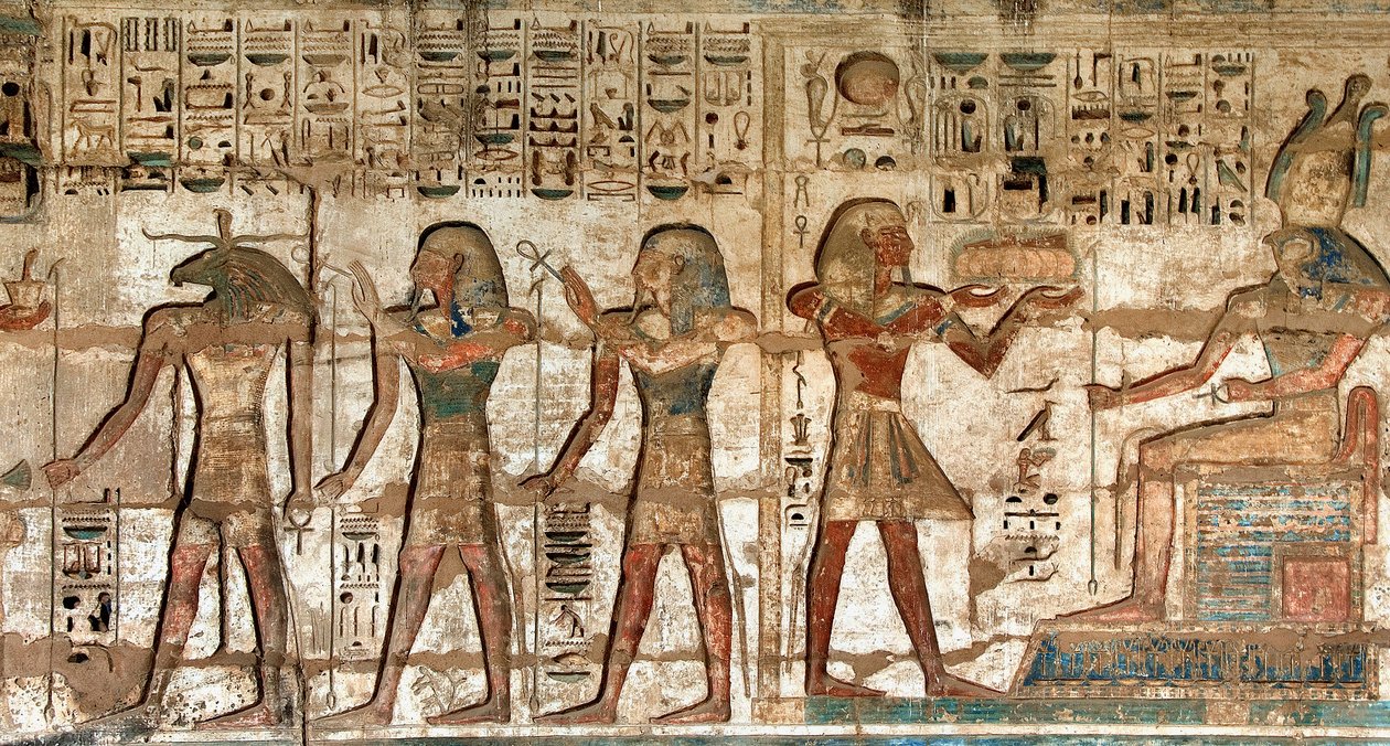 Egyptiläinen antiikki: ensimmäinen piha, yksityiskohta maalatuista reliefeistä, joissa faarao kantoi uhreja jumalille Horukselle ja Khnoumille. Ramses III:n hautaustemppeli (1187-1156 eKr.). Luxor, Medinet Habou, Egypti tekijältä Egyptian 20th Dynasty
