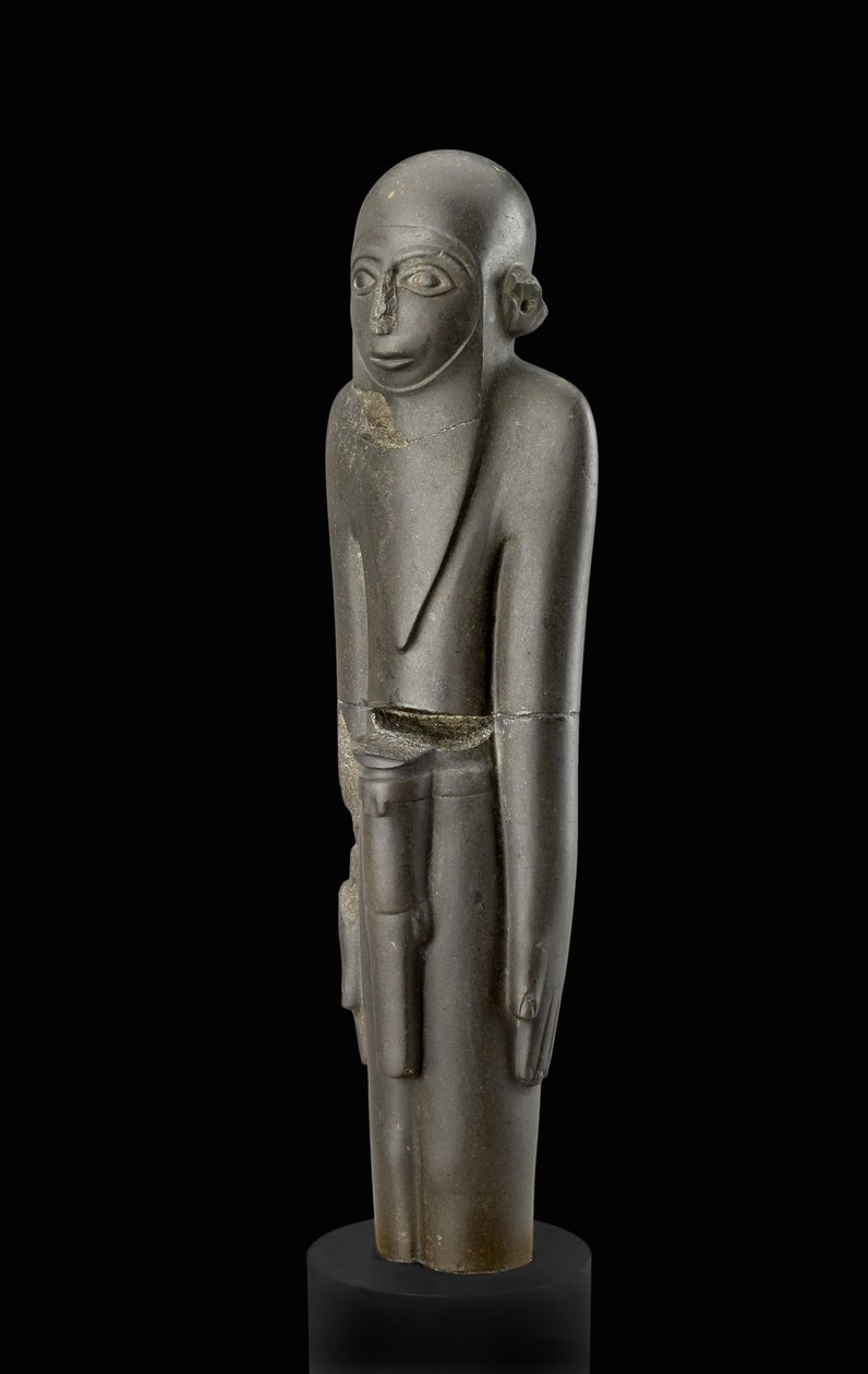 Patsas parrakkaasta miehestä, jolla on lippalakki ja vyö, jossa on penistuppi. Protodynastian ajanjakson (n. 2900-2650 eKr.) käsite (basaltti) tekijältä Egyptian 2nd Dynasty