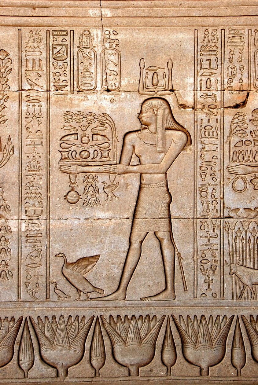Egyptiläinen antiikki: esitys miehestä, joka tuo uhreja jumalattarelle, Hathorin temppeli, Denderah, Egypti - Egyptin sivilisaatio: mies, joka kuljettaa uhreja jumalatar Hathorille, kaiverrettu Hathorin temppelin (tai Tentyran temppelin) seinälle Denderahi tekijältä Egyptian Ptolemaic Period