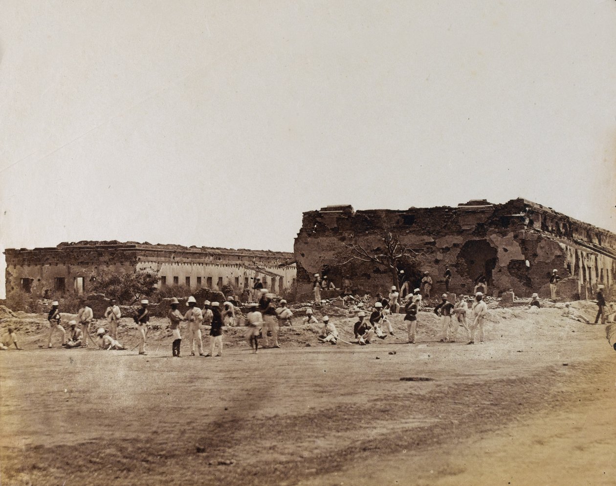Intiaanisotilaat raunioituneiden rakennusten äärellä, n. 1858 (seepiakuva) tekijältä English Photographer
