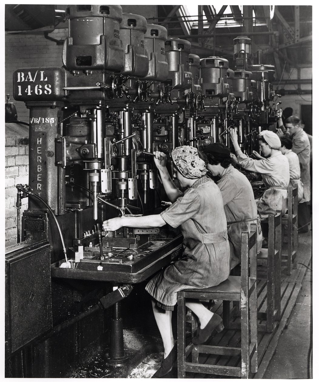 Naiset töissä, poraavat ja kalvaavat lentokoneen siipien varusteita Blackburn Aircraftiin, Olympia Works, Leeds, n. 1939-45 tekijältä English Photographer
