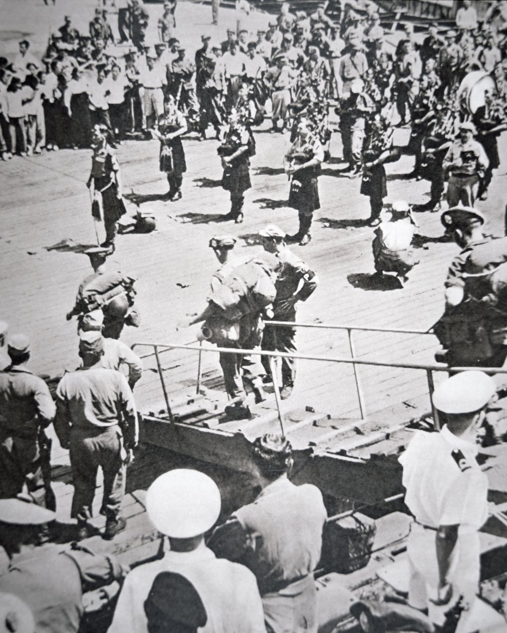 Kilted piperit soittavat maihin 1. pataljoona Argyll ja Sutherland Highlanders HMS Ceylonista Pusanissa, 29. elokuuta 1950 (m/v kuva) tekijältä English Photographer