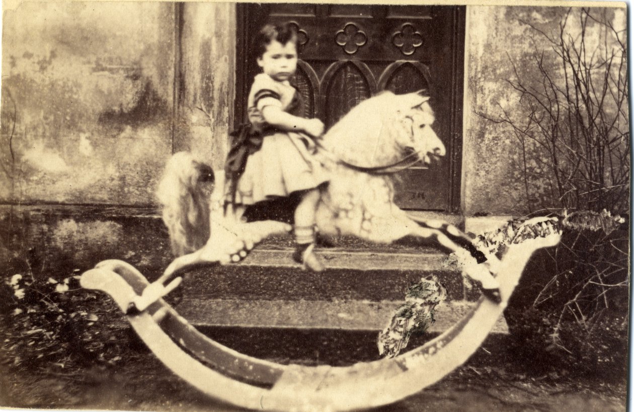 Pikkutyttö suurella keinuhevosella puutarhassa, 1860-luku (albumiprintti) tekijältä English Photographer